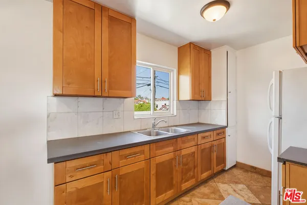 a kitchen with stainless steel appliances granite countertop a sink a stove cabinets and a window