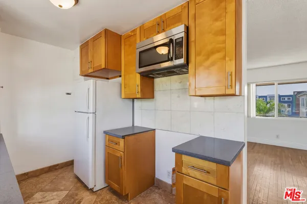 a kitchen with stainless steel appliances granite countertop a sink a stove and a wooden cabinets