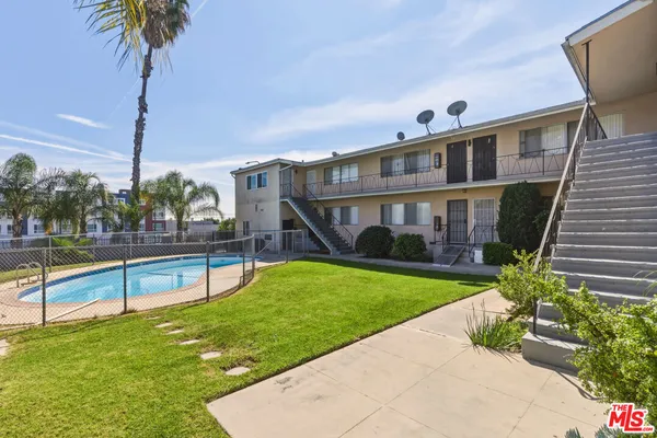 a view of a house with a yard and a palm tree