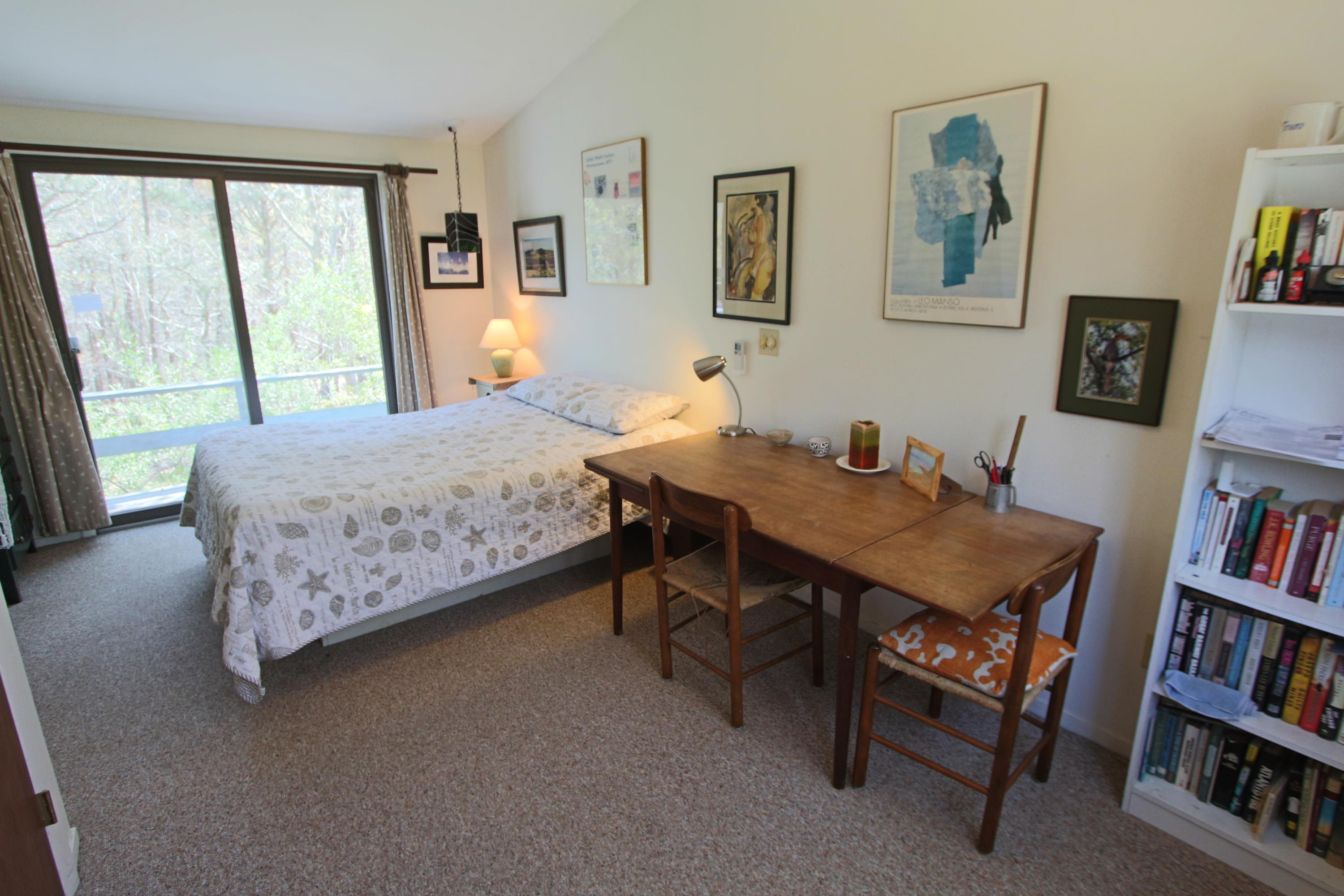 5 4th Of July Road Truro, MA 02666 - Photo 13 of 33 a bedroom with a bed a table and a book shelf
