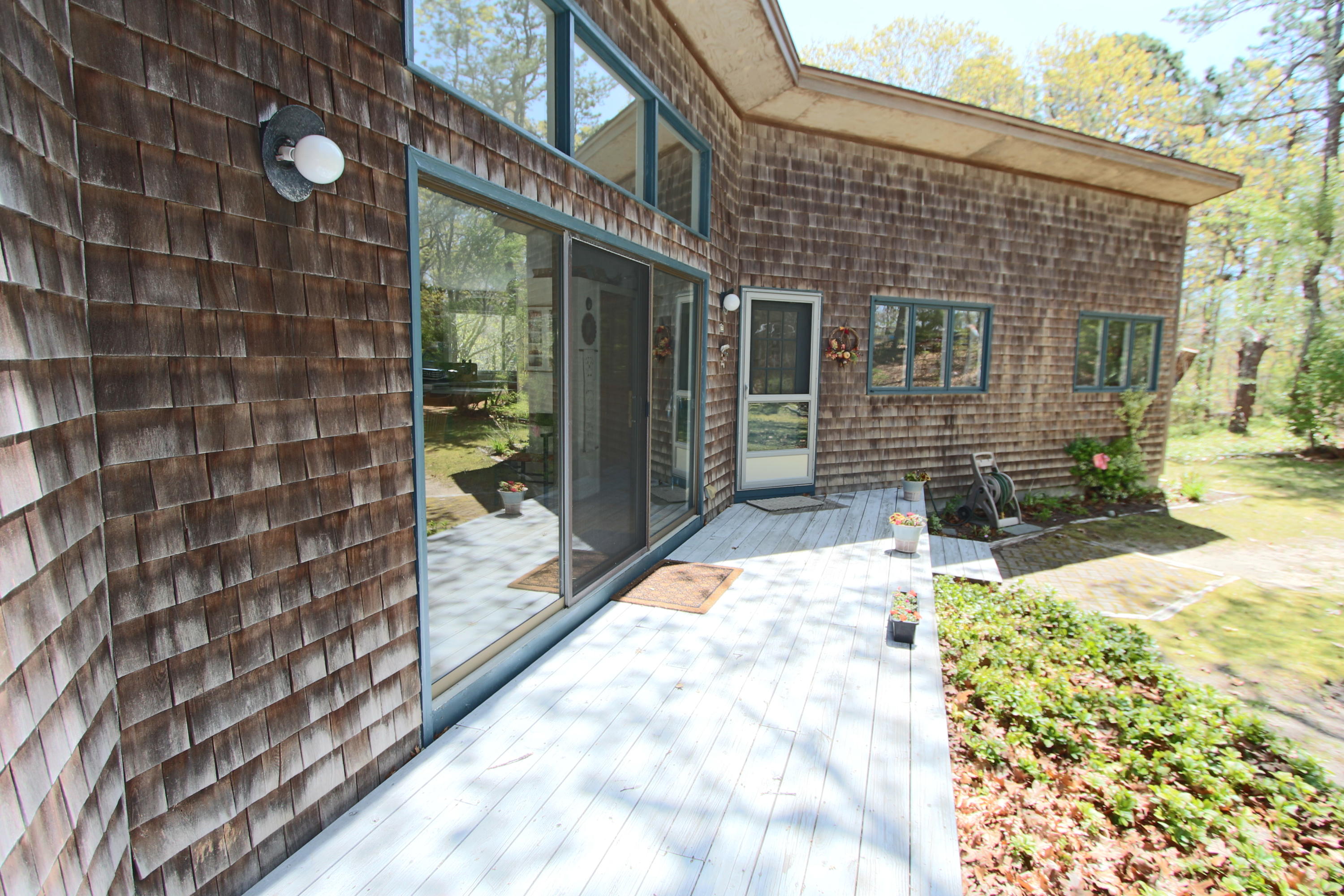 5 4th Of July Road Truro, MA 02666 - Photo 31 of 33 a view of backyard with brick wall and potted plants