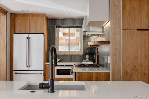 a kitchen with stainless steel appliances a refrigerator and a stove top oven