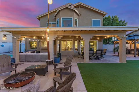 a view of a house with patio furniture and garden