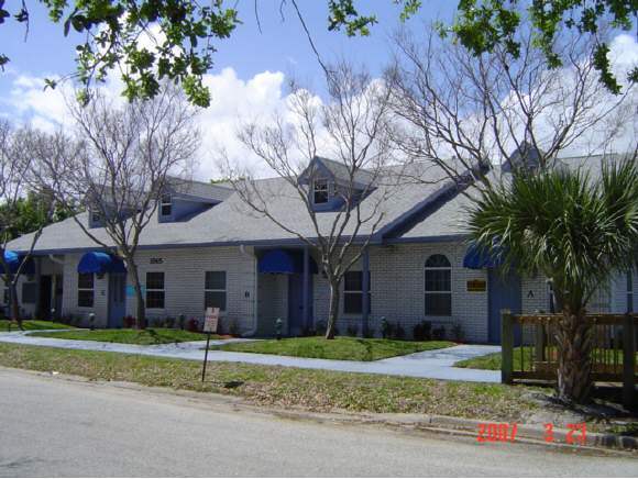 1565 Sarno Road, Unit B Melbourne, FL 32935 - Photo 1 of 2 a view of a brick house with a large windows and large trees