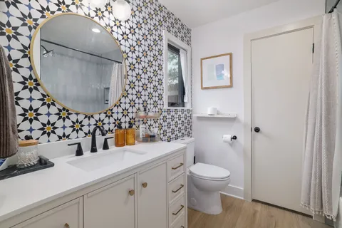 a bathroom with a sink a toilet and a mirror