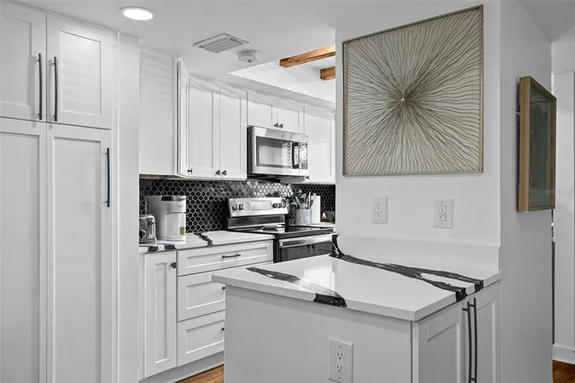 a kitchen with stainless steel appliances a white cabinets stove top oven and sink