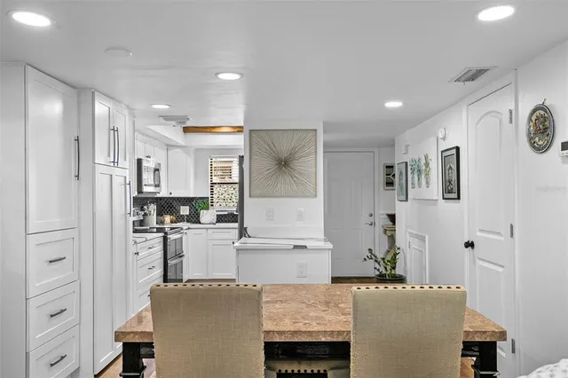 a living room with stainless steel appliances kitchen island granite countertop furniture and a refrigerator