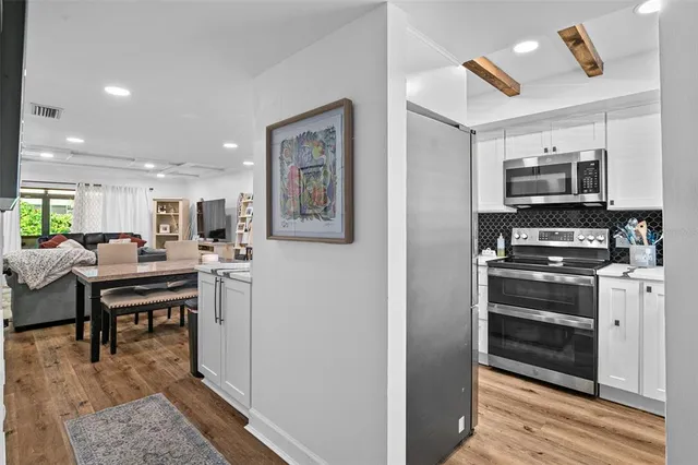 a kitchen with stainless steel appliances kitchen island granite countertop a stove and a refrigerator
