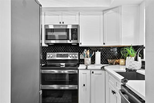 a kitchen with a sink and white cabinets