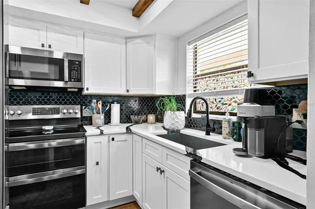 a kitchen with appliances a sink and cabinets