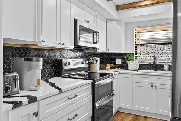 a kitchen with white cabinets and white appliances