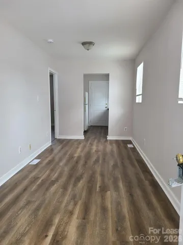 a view of a room with wooden floor and window