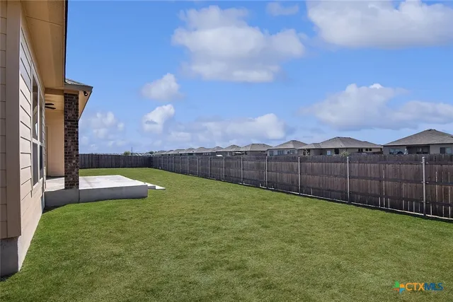 a view of a backyard with brick wall