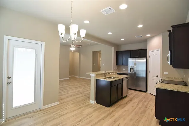 a kitchen with stainless steel appliances granite countertop a stove and a refrigerator