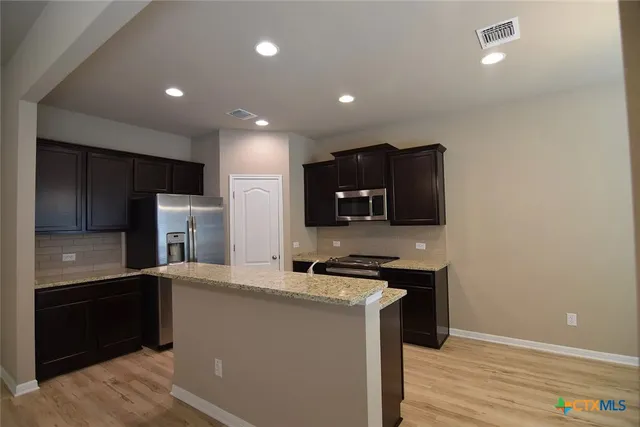 a kitchen with stainless steel appliances a refrigerator sink and microwave