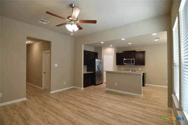 a view of a kitchen with a flat screen tv and wooden floor