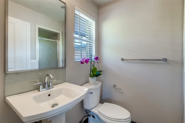 a bathroom with a sink mirror and toilet