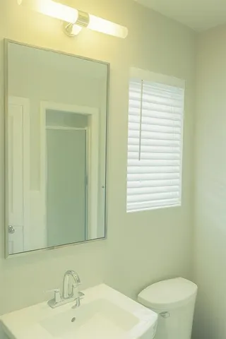 a bathroom with a sink a toilet and mirror