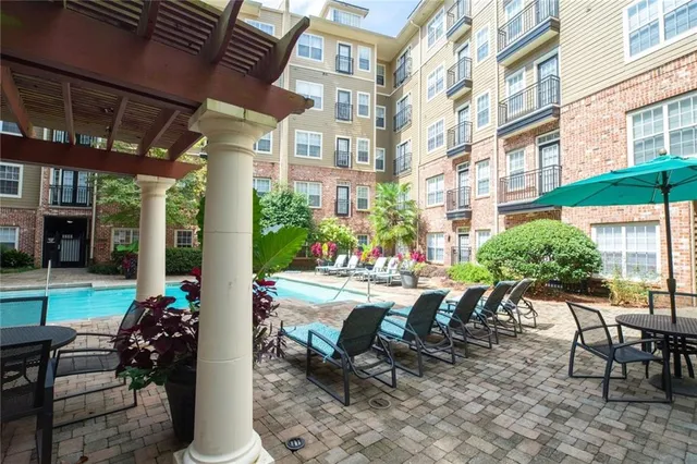 a patio with a table and chairs and potted plants
