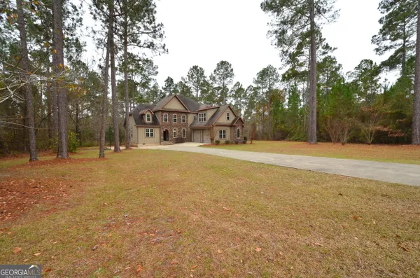 an aerial view of a house with a yard and lake view