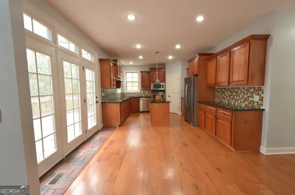 a kitchen with granite countertop white cabinets and stainless steel appliances