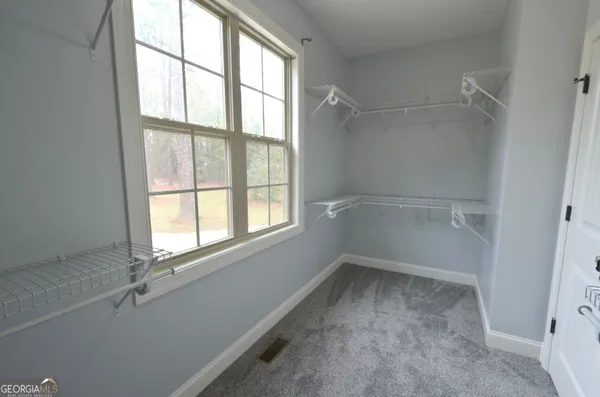 an empty room with windows and ceiling fan