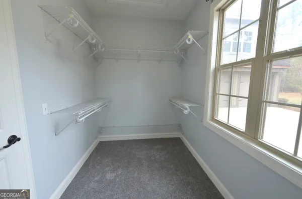 an empty room with closet and a chandelier fan