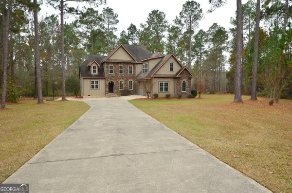 a front view of a house with a yard and trees