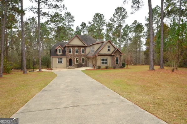a front view of a house with a yard and trees