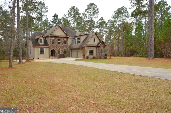 an aerial view of residential house with outdoor space and trees all around