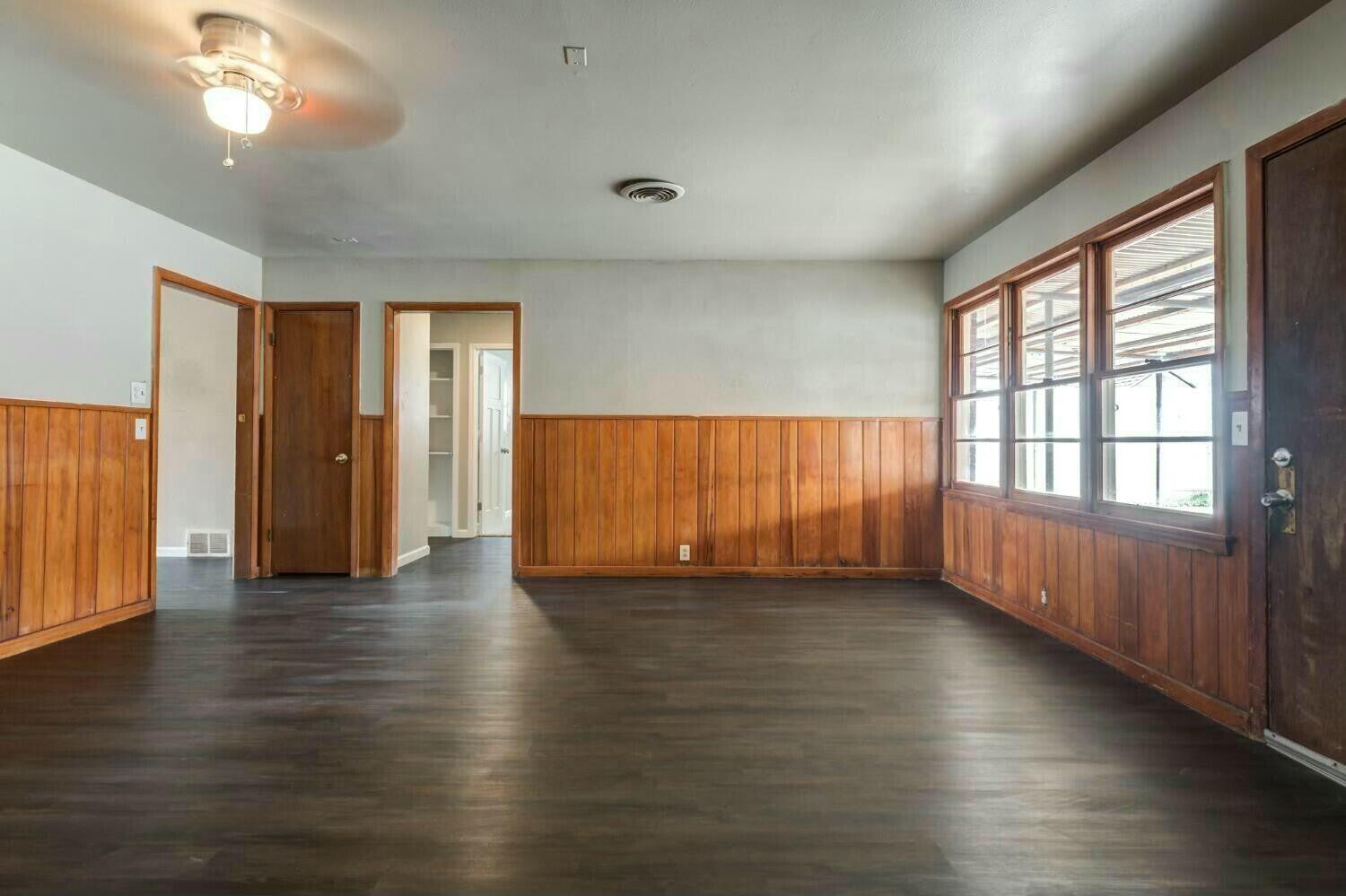 4407 49th Street Lubbock, TX 79414 - Photo 12 of 23 an empty room with wooden floor and windows