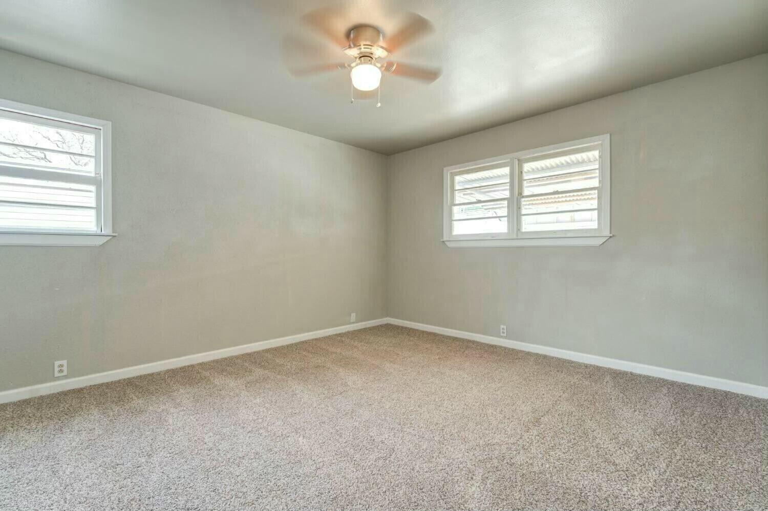 4407 49th Street Lubbock, TX 79414 - Photo 18 of 23 an empty room with a window and a ceiling fan