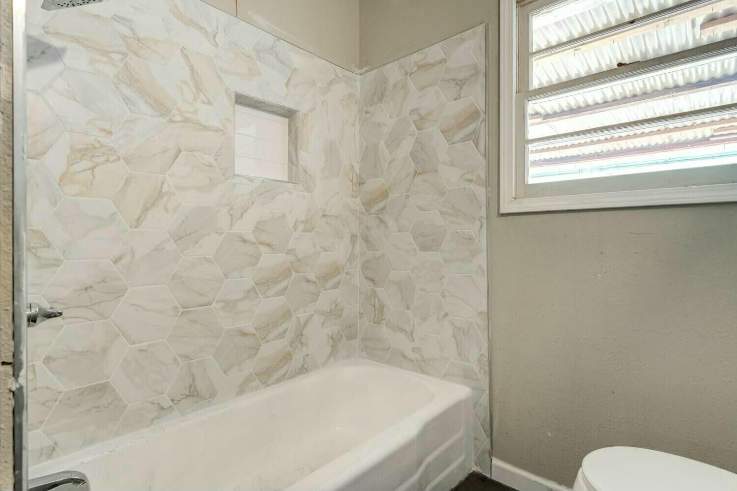 4407 49th Street Lubbock, TX 79414 - Photo 22 of 23 a bathroom with a bathtub and a shower