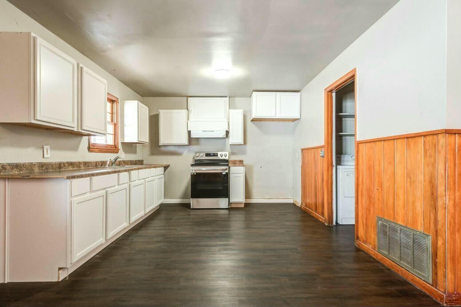 4407 49th Street Lubbock, TX 79414 - Photo 8 of 23 a kitchen with stainless steel appliances granite countertop a refrigerator a sink dishwasher a stove and white countertops with wooden floor