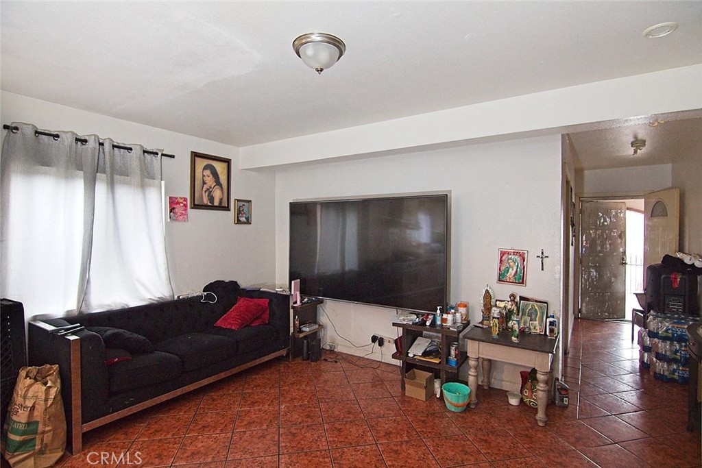 6911 Compton Avenue Los Angeles, CA 90001 - Photo 11 of 34 a living room with furniture and a flat screen tv