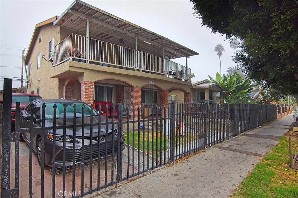 6911 Compton Avenue Los Angeles, CA 90001 - Photo 12 of 34 a front view of a house with iron fence