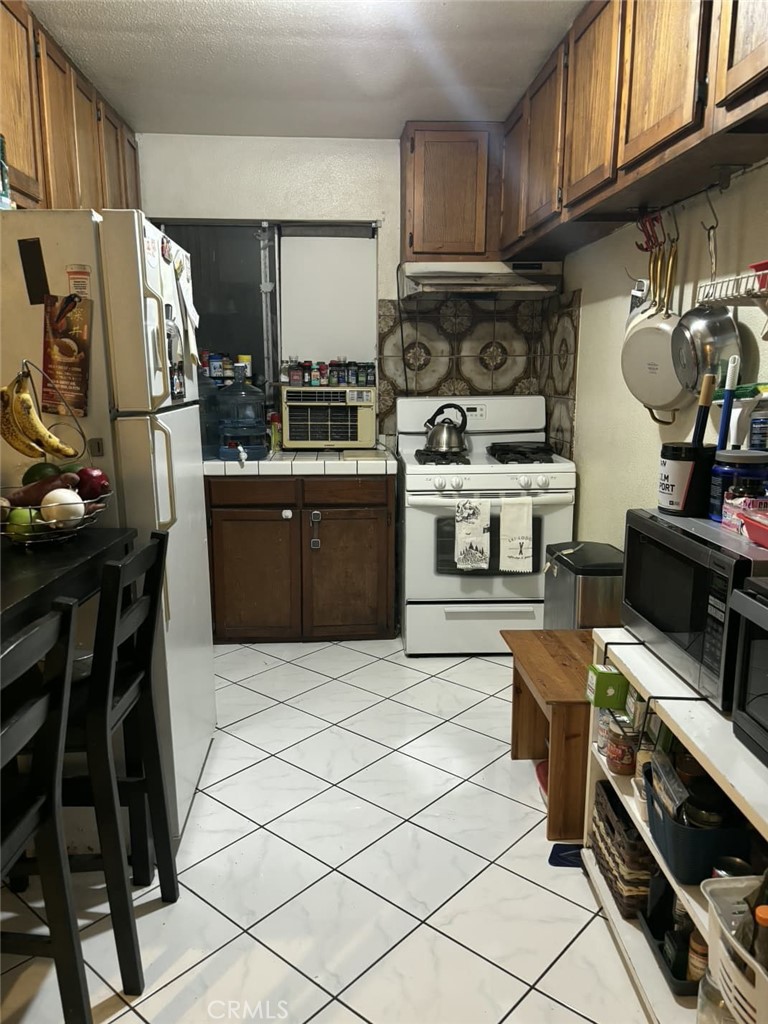 6911 Compton Avenue Los Angeles, CA 90001 - Photo 15 of 34 a kitchen with stainless steel appliances a stove a sink and a refrigerator