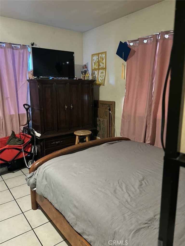 6911 Compton Avenue Los Angeles, CA 90001 - Photo 21 of 34 a bedroom with a bed and flat screen tv