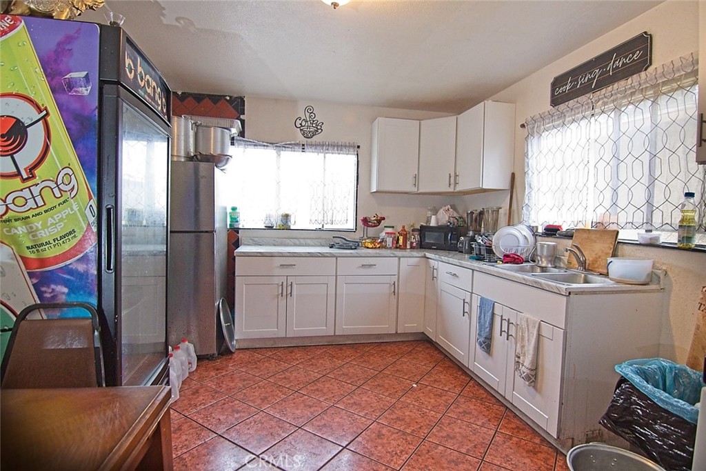 6911 Compton Avenue Los Angeles, CA 90001 - Photo 3 of 34 a kitchen with stainless steel appliances a white cabinets and a window