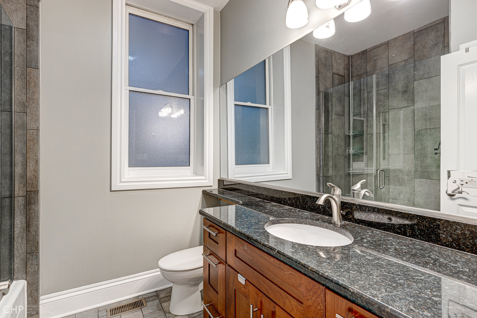 2116 West Potomac Avenue, Unit 1 Chicago, IL 60622 - Photo 11 of 24 a bathroom with a granite countertop sink a toilet and a mirror