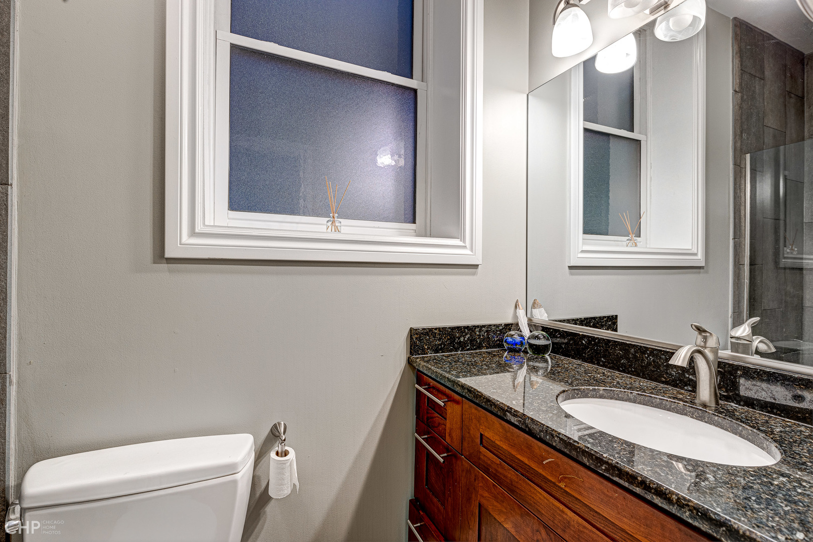 2116 West Potomac Avenue, Unit 1 Chicago, IL 60622 - Photo 21 of 24 a bathroom with a granite countertop sink toilet and mirror