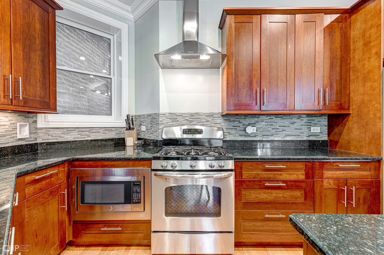 2116 West Potomac Avenue, Unit 1 Chicago, IL 60622 - Photo 8 of 24 a kitchen with stainless steel appliances granite countertop a stove and a microwave