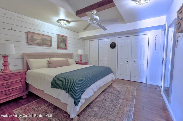 a view of a white house next to a yard with road and trees