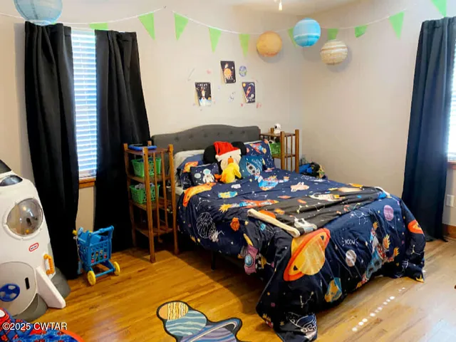 a bedroom with a bed and a mirror on the dresser