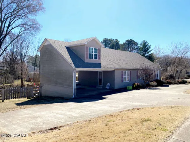 a front view of a house with a yard covered in snow