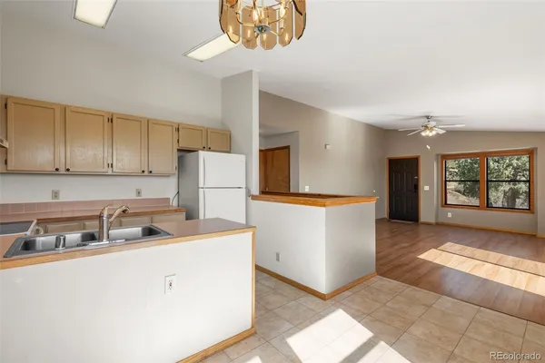a kitchen with kitchen island white cabinets and refrigerator