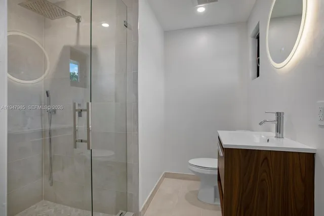 a bathroom with a toilet a sink a vanity and mirror