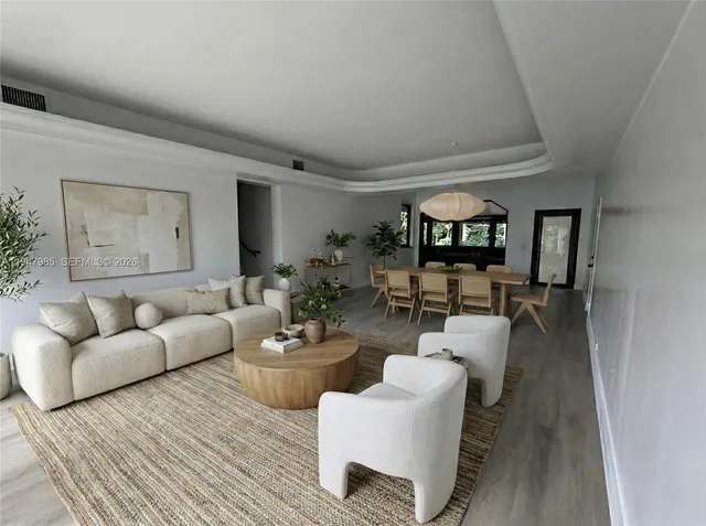 a living room with furniture and a wooden floor