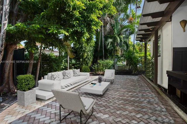 a view of a patio with table and chairs potted plants and large tree