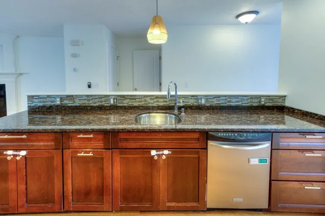 a view of a kitchen with granite countertop cabinets and chandelier